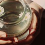 A close-up of a serene floral tea held gently in hands, promoting relaxation.